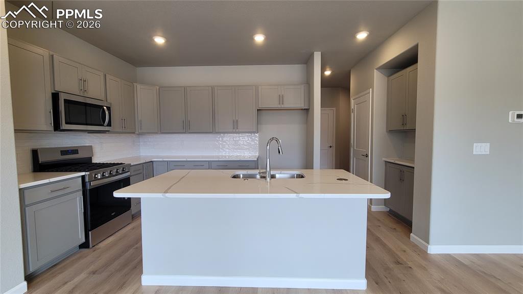 Image 7 of 36: Kitchen with quartz countertops, pantry, large island providing additional 