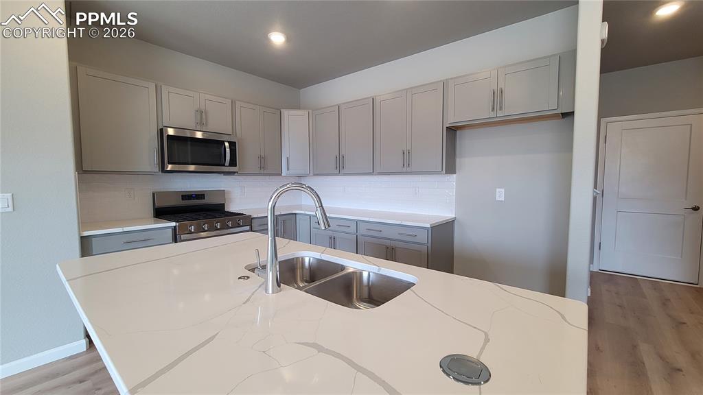 Image 8 of 36: Kitchen with quartz countertops, pantry, large island providing additional 