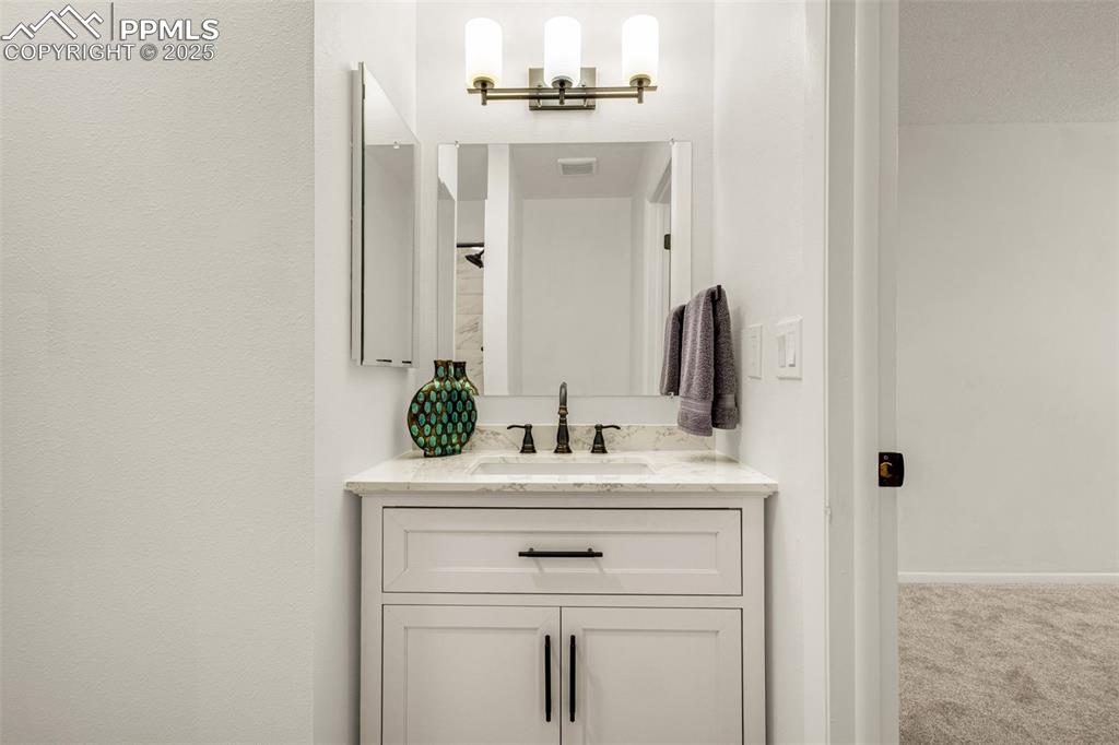 Image 11 of 27: Bathroom featuring vanity and baseboards