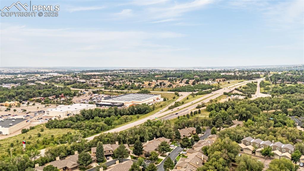 Image 26 of 27: Aerial perspective of suburban area featuring a tree filled landscape