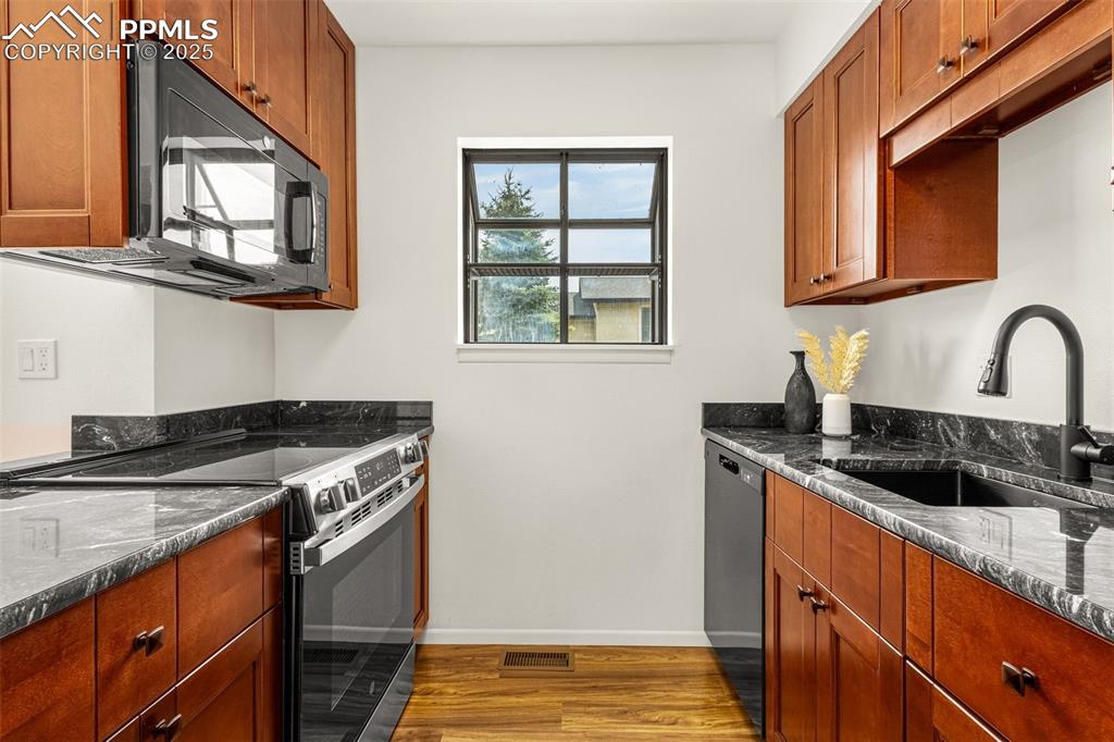 Image 5 of 27: Kitchen with stainless steel electric range oven, dark wood-style floors, b