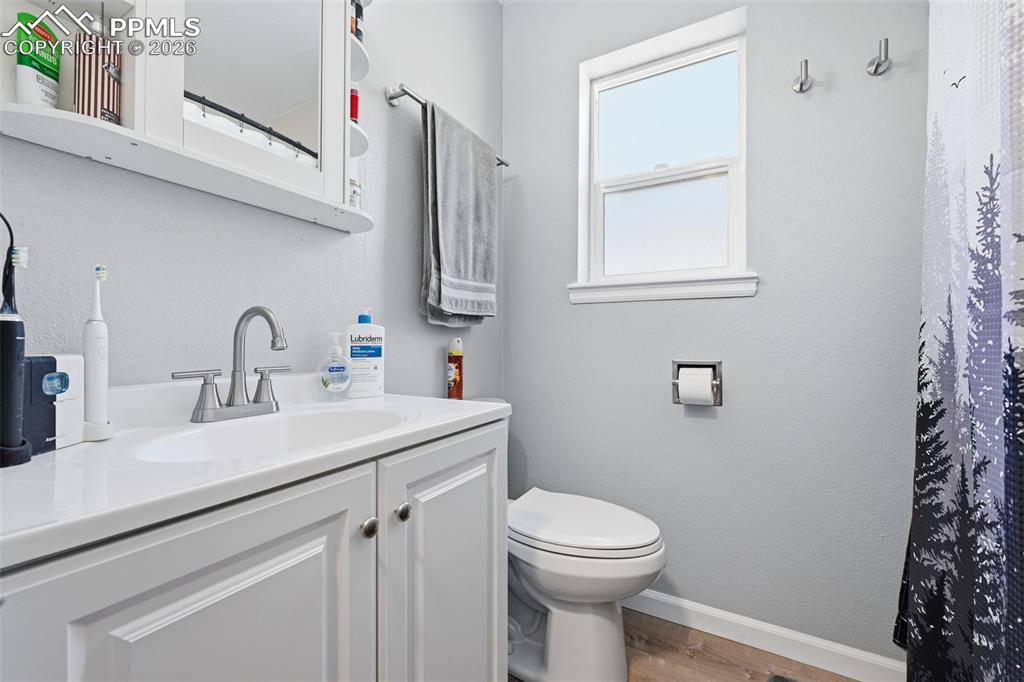 Image 13 of 28: Bathroom featuring a single-sink vanity with white cabinetry, a built-in me