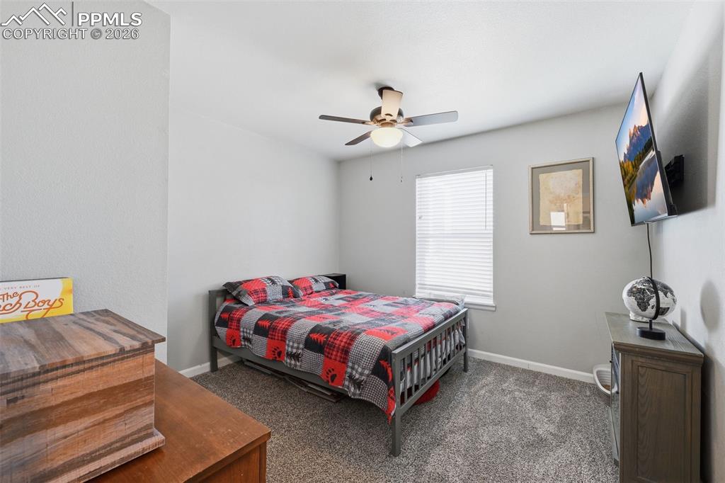 Image 18 of 28: Carpeted interior space featuring a window with blinds, a ceiling fan, and 