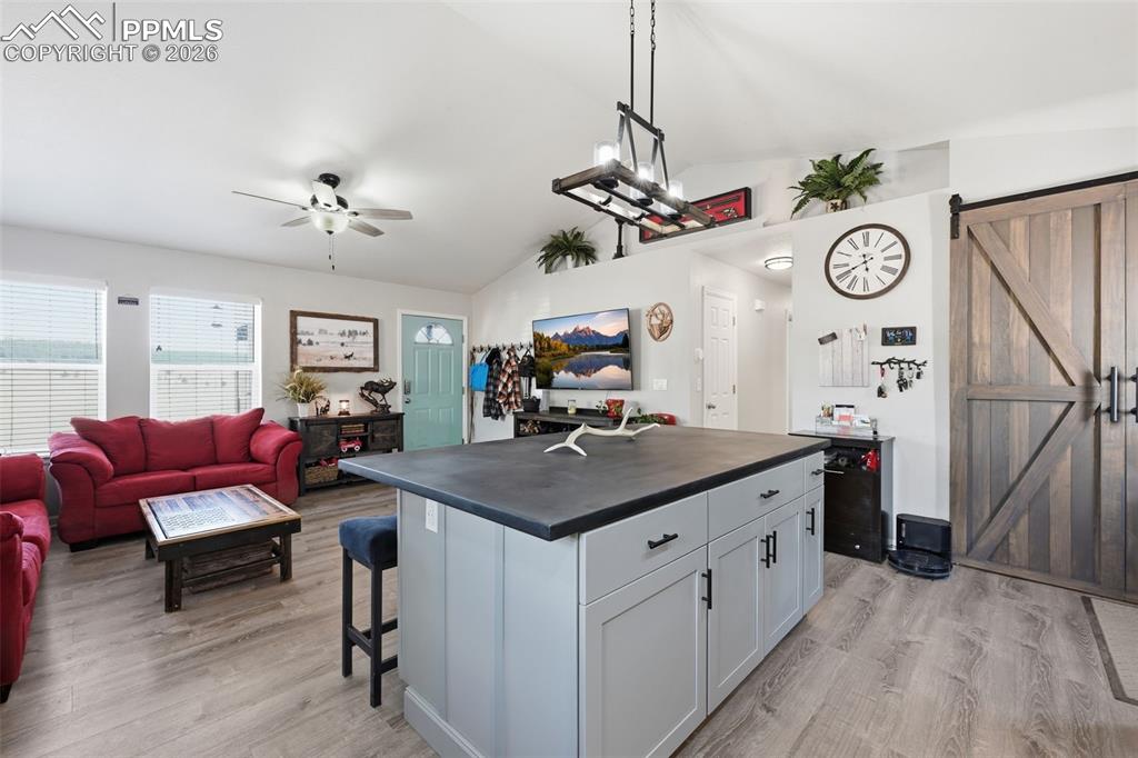 Image 7 of 28: Spacious open-concept interior featuring light wood-finish flooring and a v