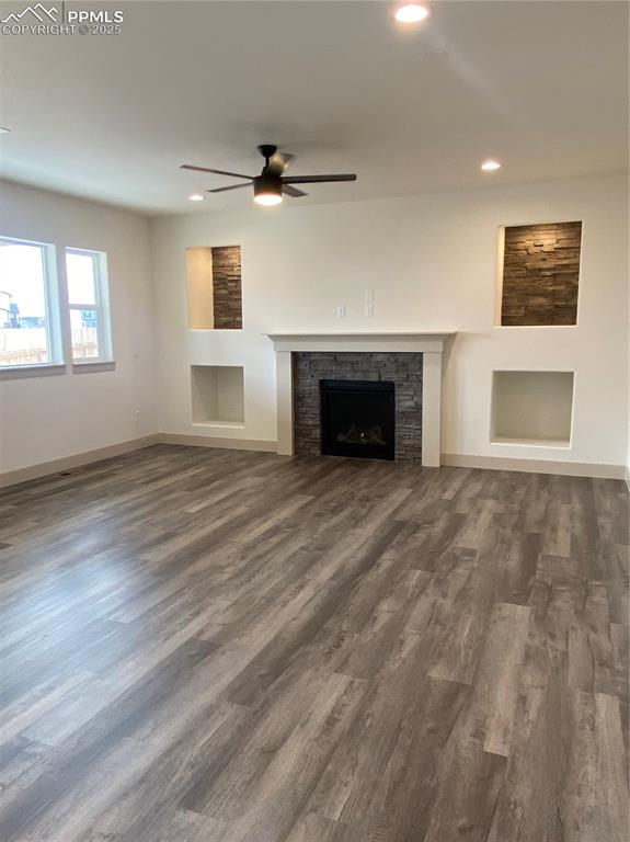 Image 12 of 35: Unfurnished living room featuring a fireplace, built in features, recessed 