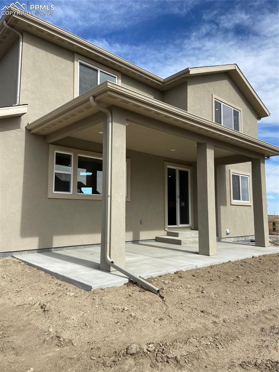 Image 33 of 35: Rear view of property featuring stucco siding and a patio
