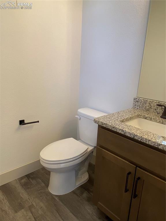 Image 7 of 35: Half bath featuring dark wood-style flooring and vanity