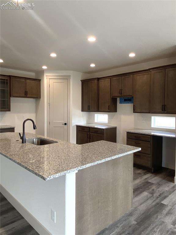 Image 9 of 35: Kitchen featuring dark wood-style floors, recessed lighting, light stone co
