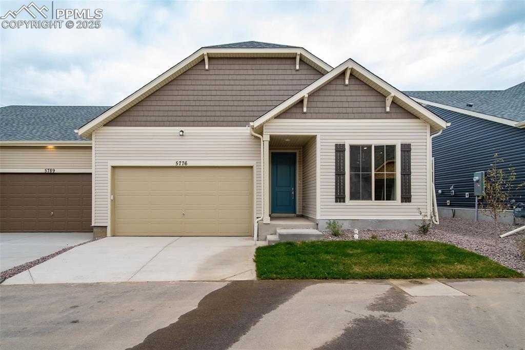 Caption: View of front of property featuring concrete driveway and an attached garage