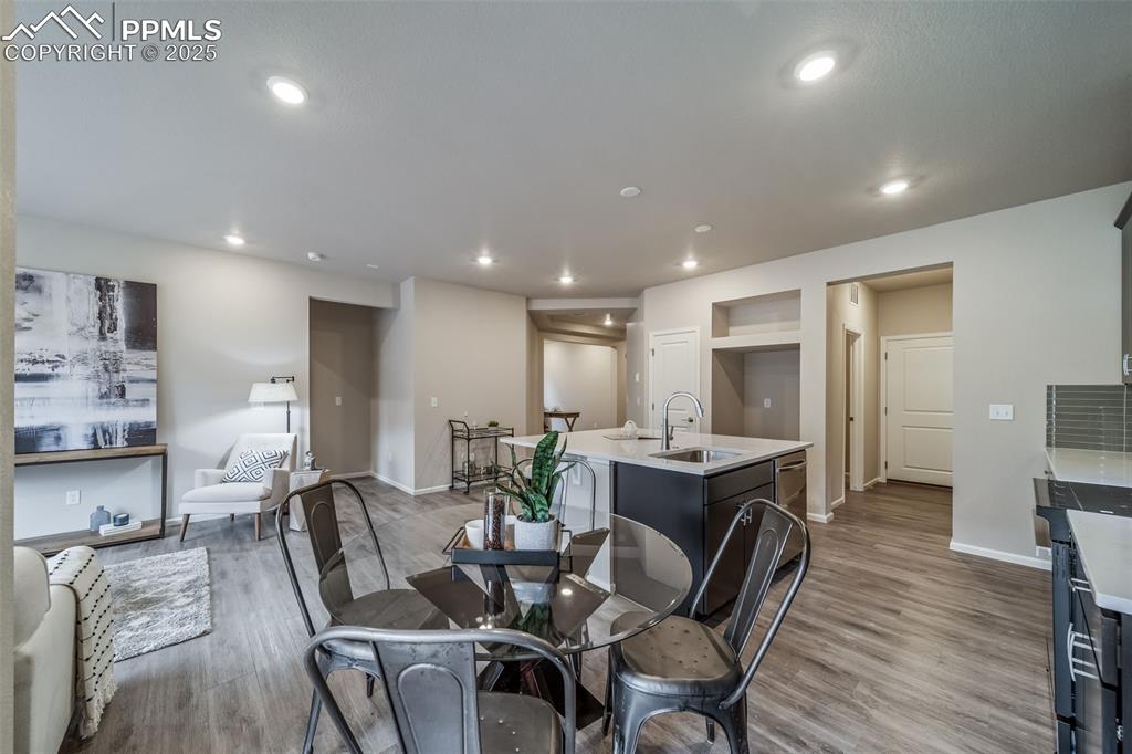 Image 9 of 25: Dining area with light wood-style flooring and recessed lighting