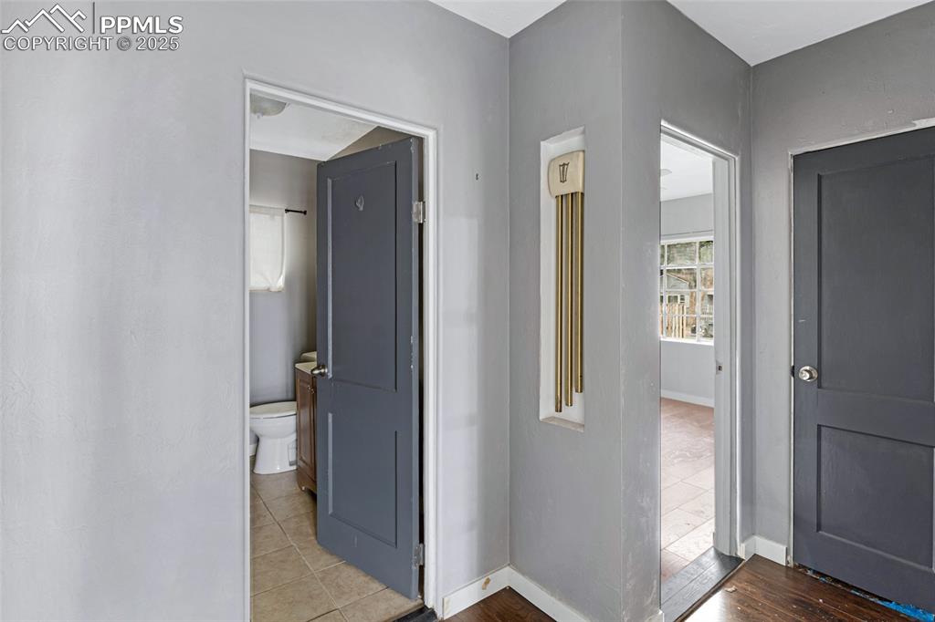 Image 10 of 16: Corridor featuring baseboards and tile patterned flooring