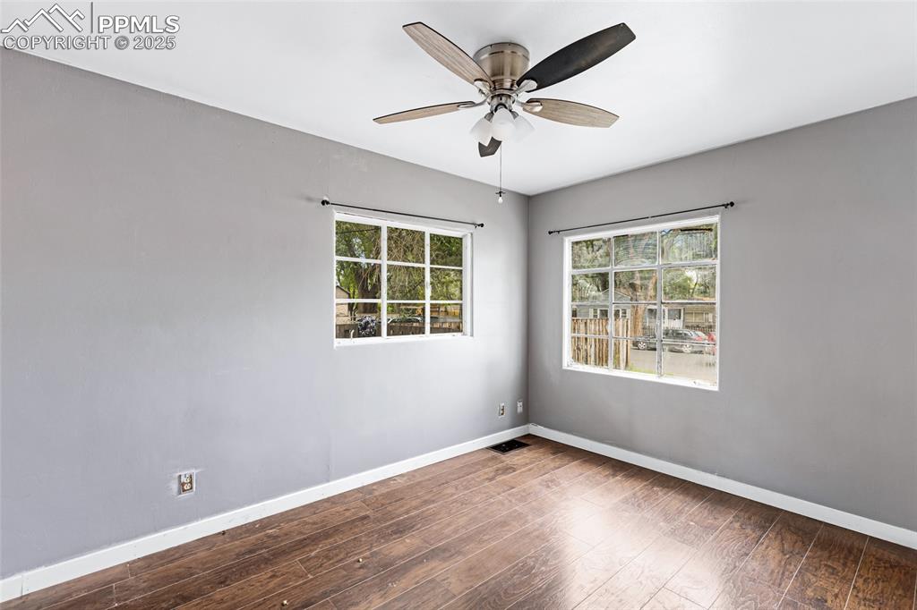 Image 11 of 16: Unfurnished room with plenty of natural light, wood finished floors, and a 