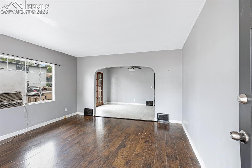 Image 4 of 16: Unfurnished living room featuring arched walkways, hardwood / wood-style fl