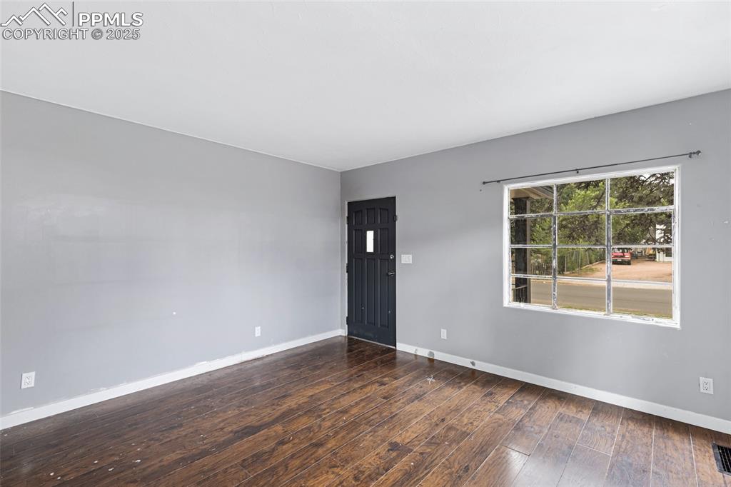 Image 5 of 16: Spare room with baseboards and hardwood / wood-style flooring