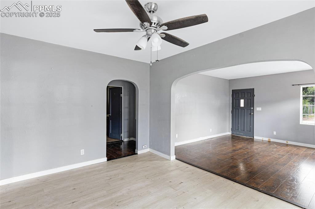 Image 7 of 16: Unfurnished room featuring arched walkways, ceiling fan, and wood finished 