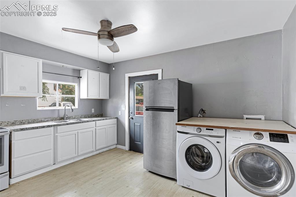 Image 8 of 16: Laundry area featuring washer and dryer, a ceiling fan, and light wood-styl