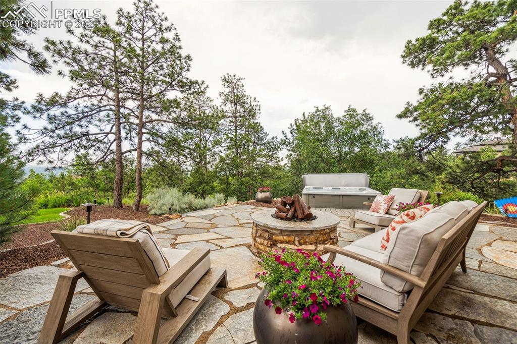 Image 47 of 50: Lower patio with fireplace and hot tub