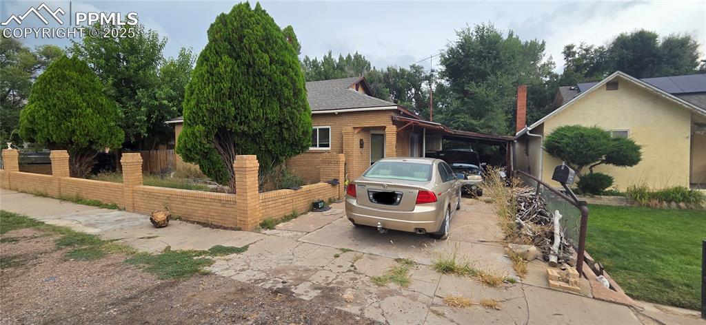 Image 2 of 2: View of property exterior featuring brick siding, roof with shingles, and d