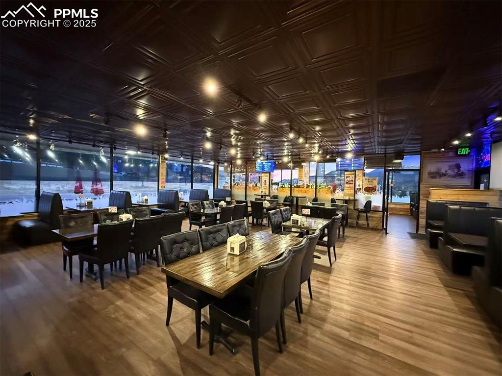 Image 7 of 10: Dining area with wood finished floors and an ornate ceiling