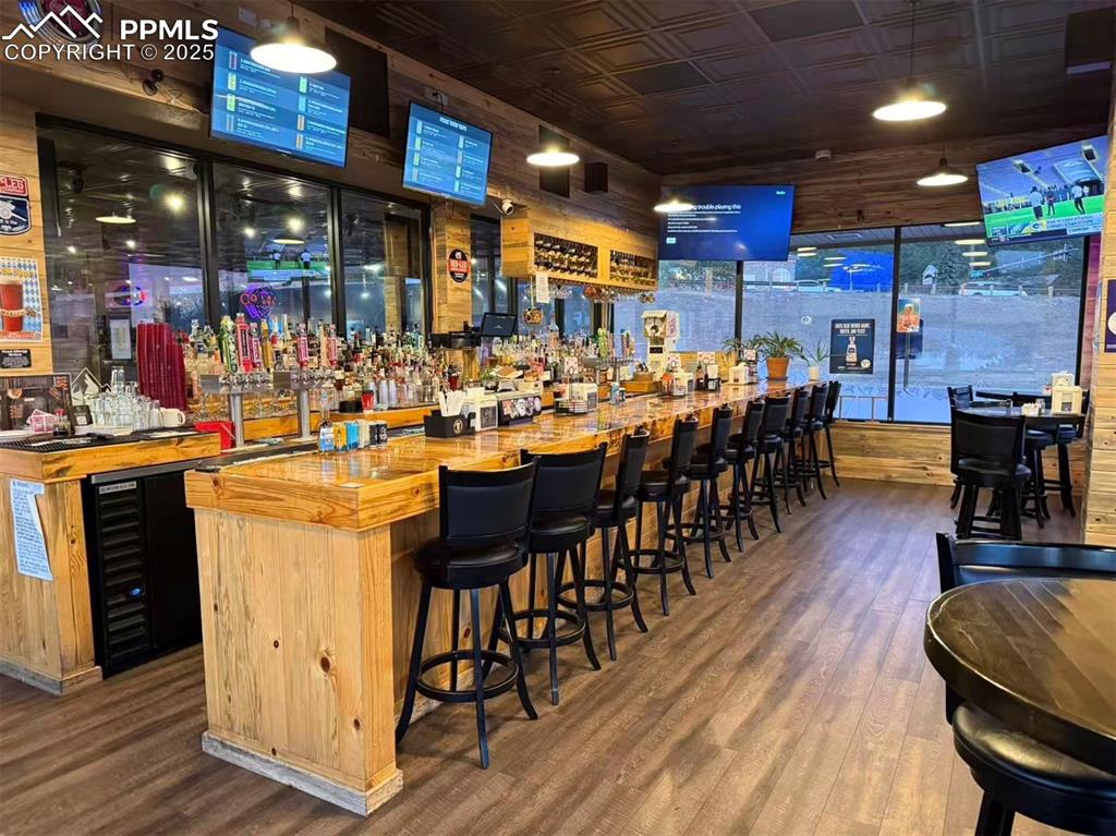 Image 8 of 10: Community bar area with an ornate ceiling, wine cooler, butcher block count