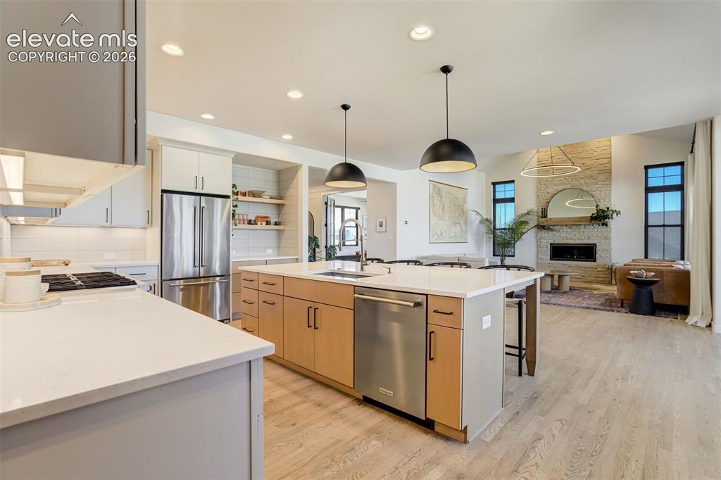 Image 11 of 50: Gourmet kitchen featuring a large central island with pendant lighting, sta