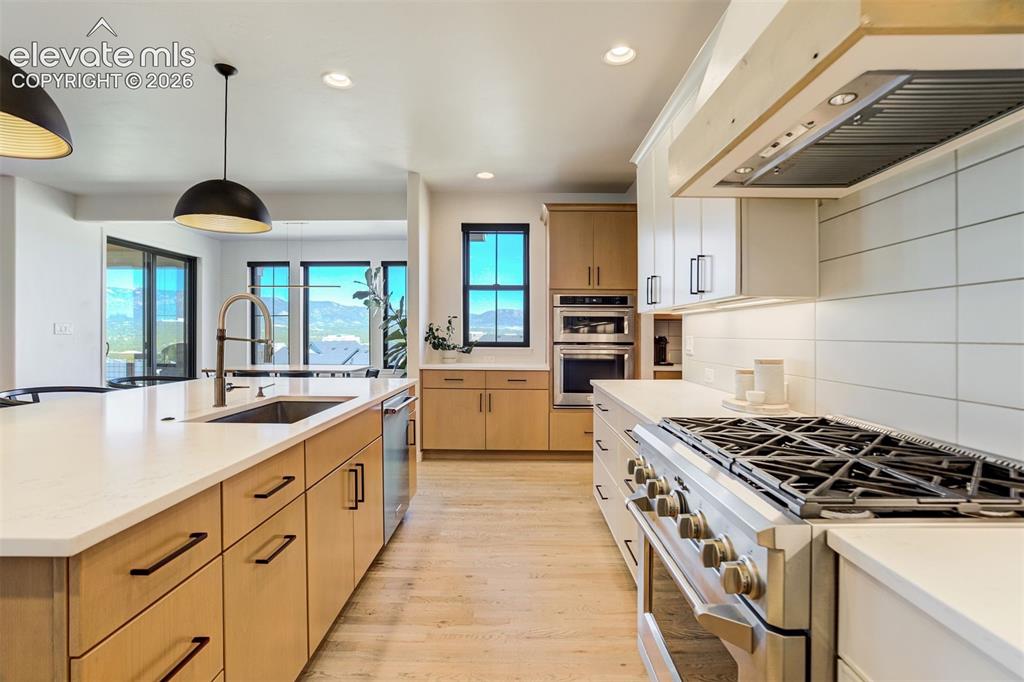 Image 14 of 50: Modern kitchen featuring light wood-finish cabinetry and light countertops