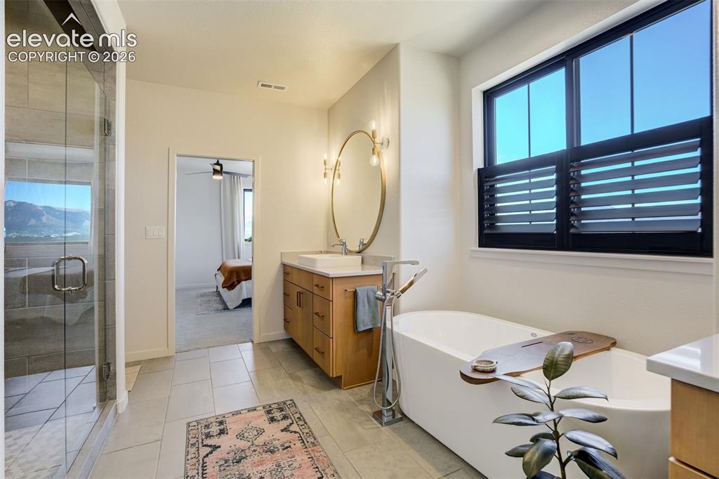 Image 29 of 50: Contemporary bathroom featuring a freestanding soaking tub with a floor-mou