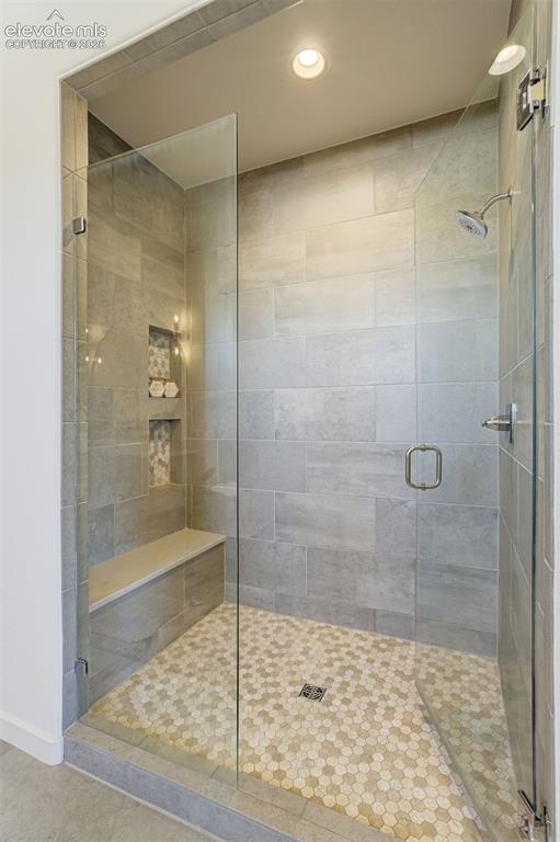 Image 31 of 50: Walk-in shower featuring clear glass enclosure, gray subway tile walls, a b