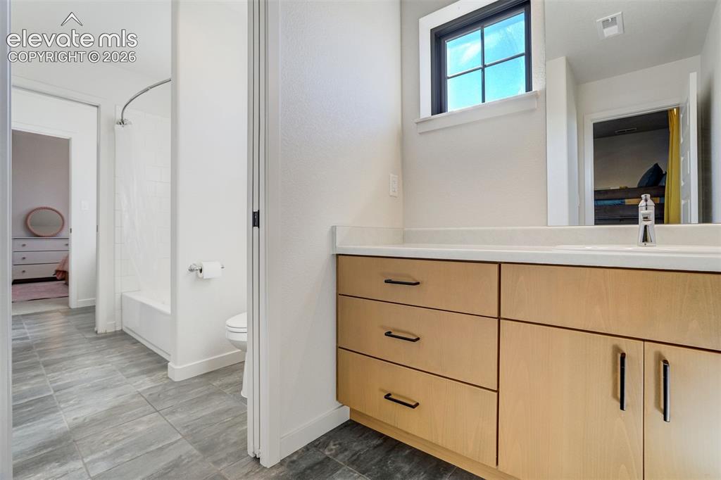 Image 37 of 50: Contemporary bathroom featuring a light wood-finish vanity with ample stora