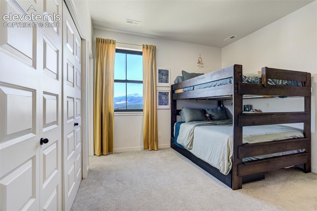 Image 38 of 50: Room featuring light-toned carpeting, a window with mountain scenery, and w