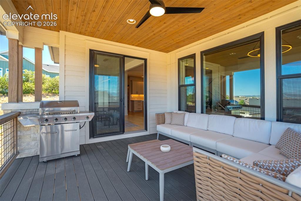 Image 43 of 50: Covered outdoor patio featuring a wood-finish ceiling with a ceiling fan, c