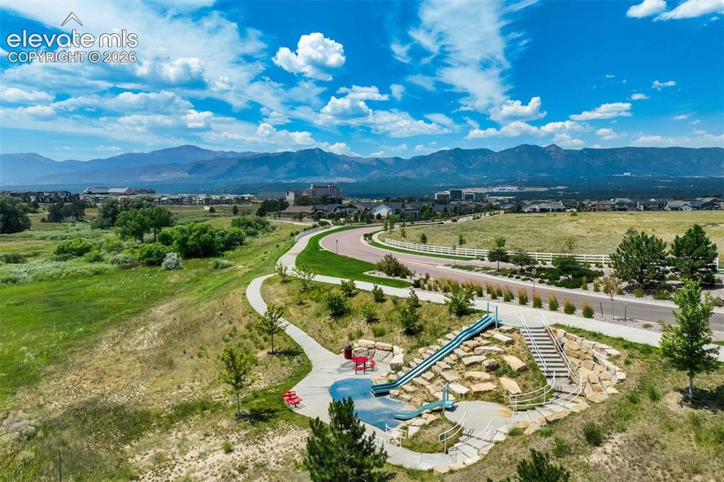 Image 50 of 50: Community park area featuring a rock-scaped slide, stairs, and walking path
