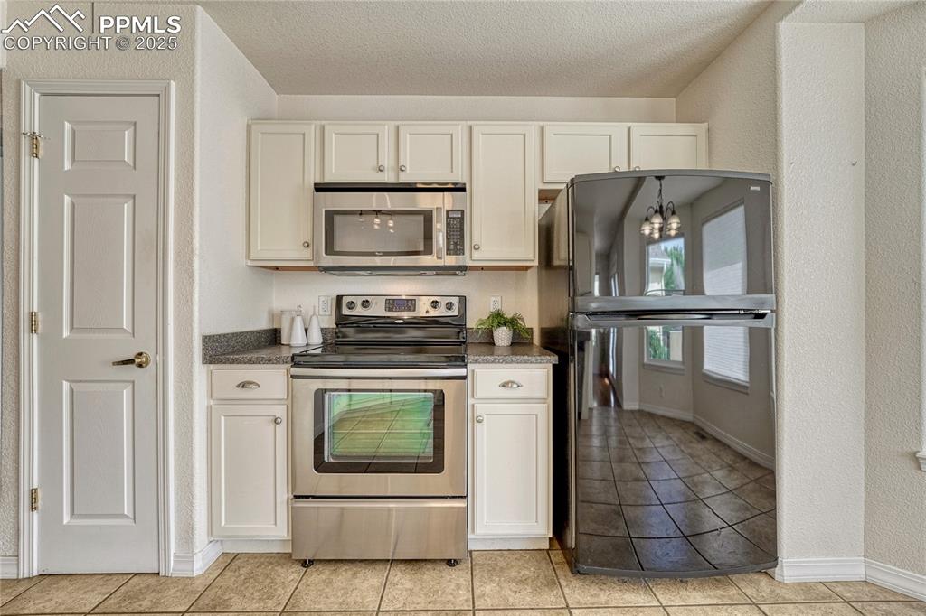 Image 12 of 47: Stainless steel range oven and microwave oven with the kitchen pantry to th