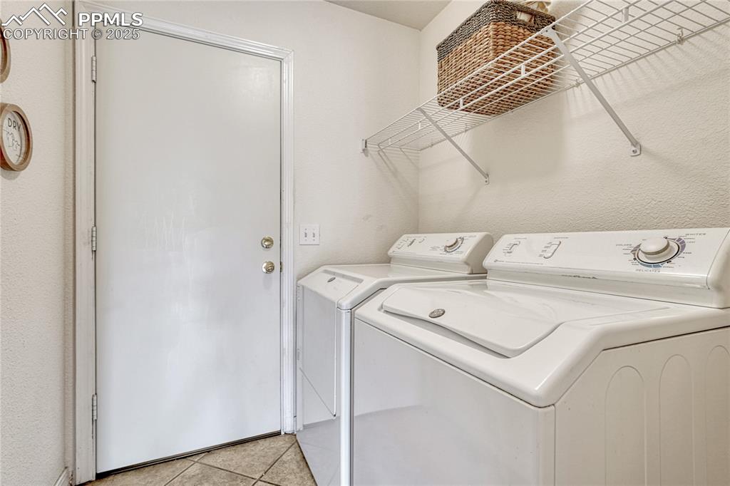 Image 16 of 47: Just off the hall is the laundry room with ceramic tile floor and a door to