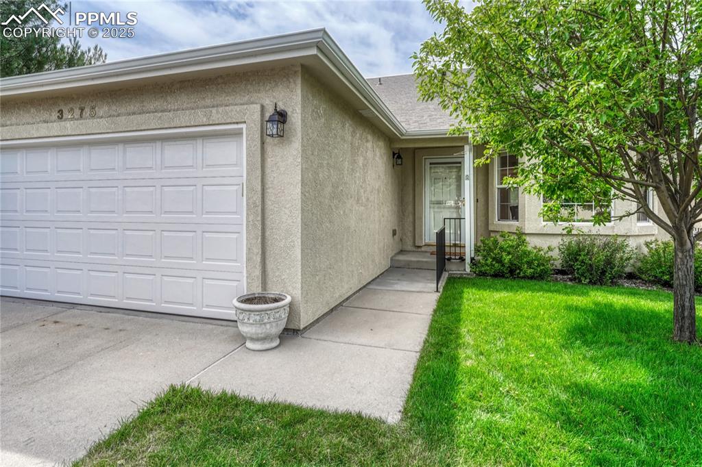 Image 2 of 47: Stucco exterior with 2-car garage in front of the home and a covered front