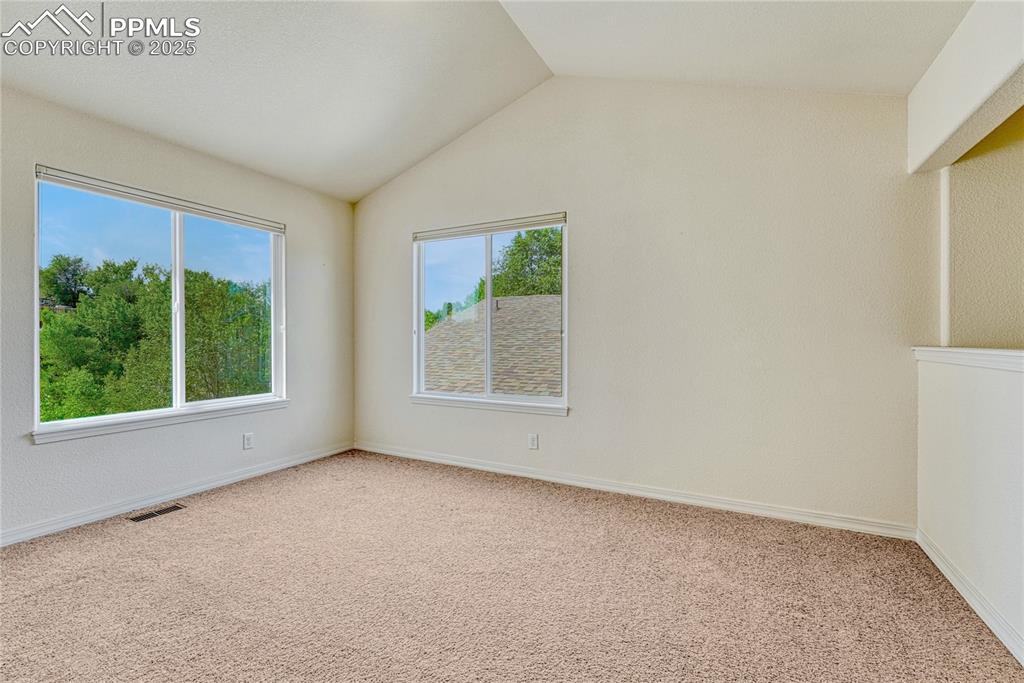 Image 27 of 47: The loft is also vaulted and is filled with light from the large windows