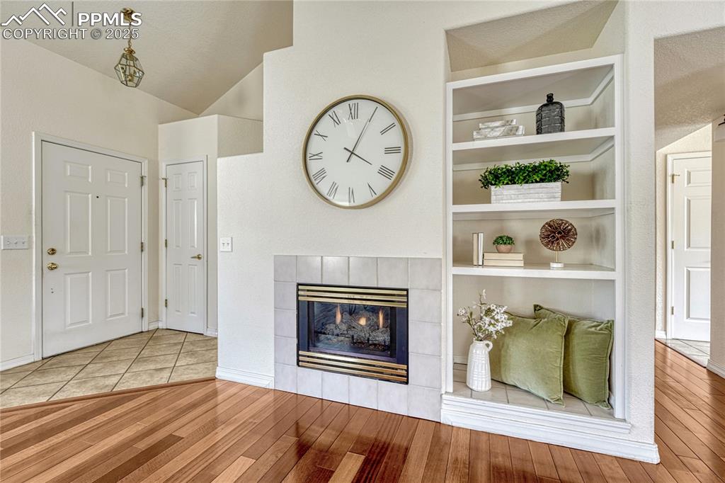 Image 3 of 47: Tiled fireplace surround and ceramic tile floor by the entry door and coat