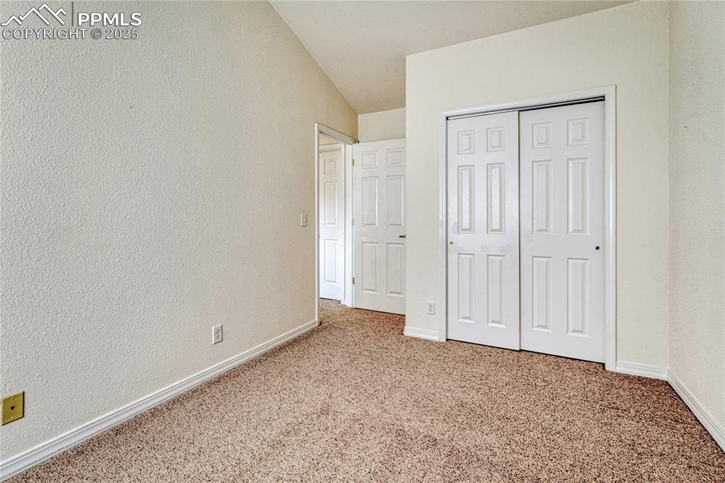 Image 30 of 47: The first upper-level bedroom with vaulted ceiling and closet