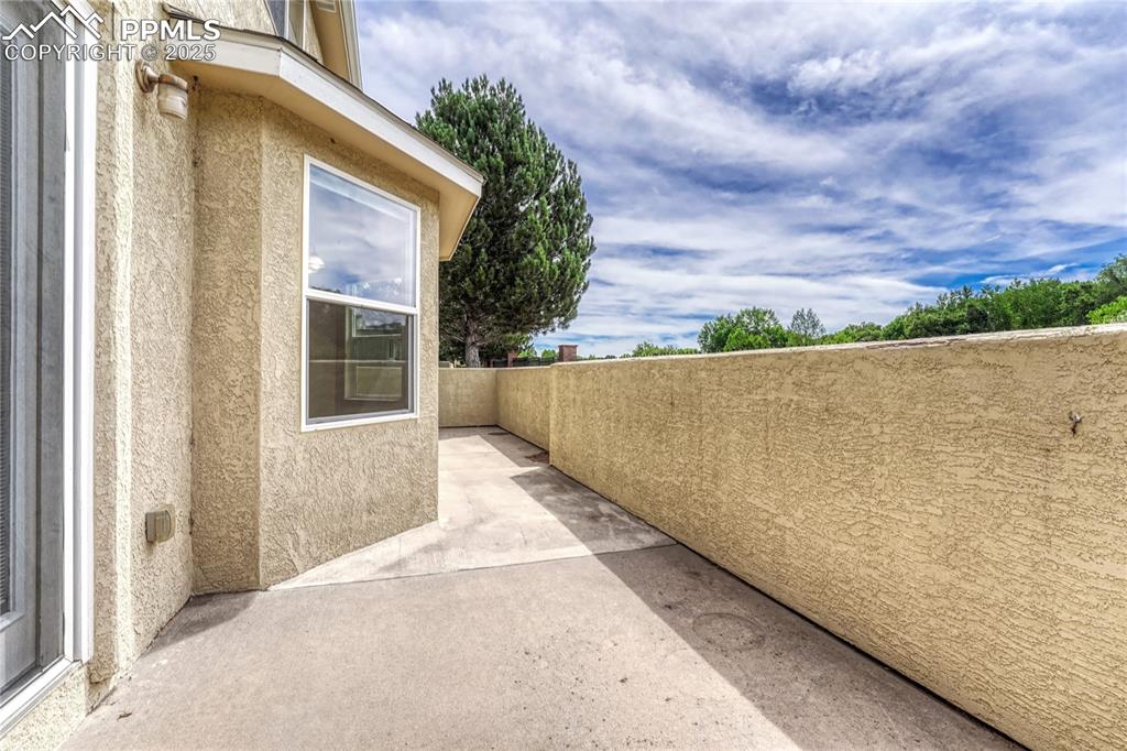 Image 37 of 47: The patio stretches the entire width of the home and has stucco walls