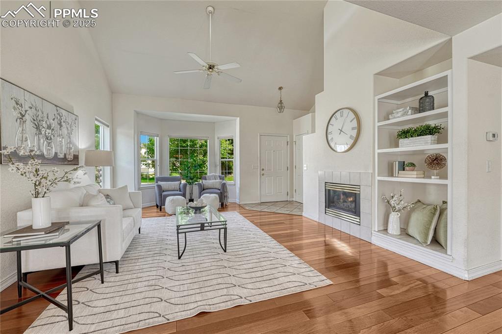 Image 4 of 47: Large living room with a bay window and built-in shelving aside the firepla