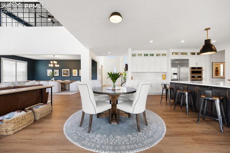 Image 19 of 49: Dining area featuring a chandelier, wood finished floors, and recessed ligh