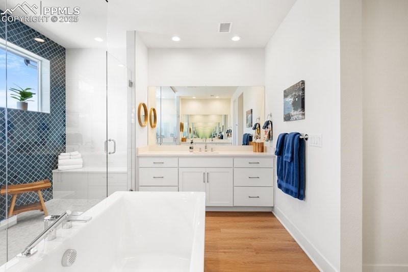 Image 28 of 49: Bathroom featuring a freestanding bath, vanity, a shower stall, wood finish