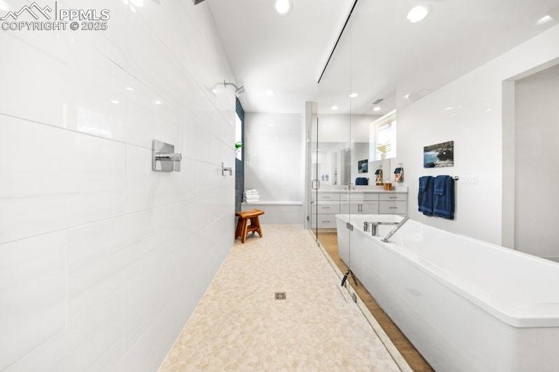 Image 29 of 49: Bathroom with a soaking tub, vanity, recessed lighting, and a shower