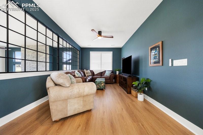 Image 30 of 49: Living room featuring a ceiling fan, wood finished floors, and baseboards