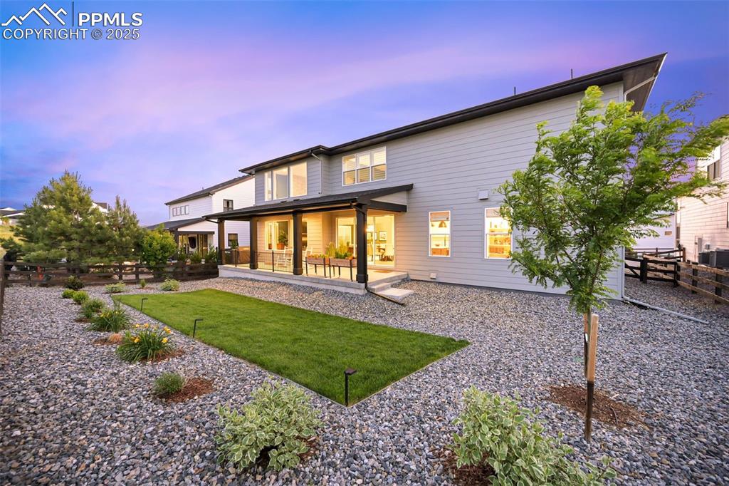 Image 4 of 49: Back of property at dusk featuring a patio area