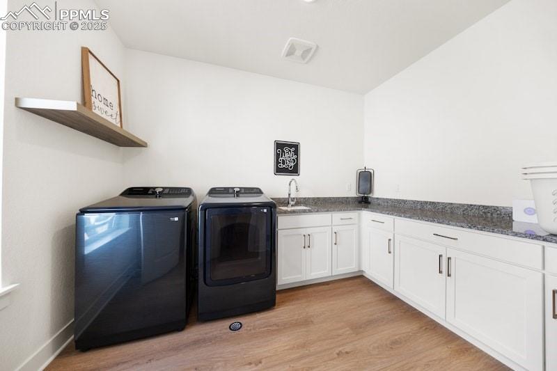 Image 40 of 49: Laundry area with washing machine and dryer, light wood-type flooring, and