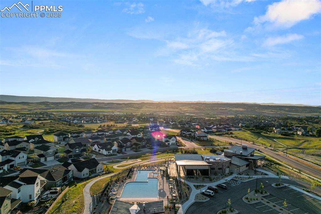 Image 43 of 49: Aerial view of residential area featuring a pool area and mountains