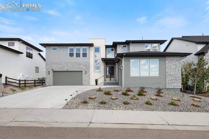 Image 6 of 49: View of front of house with concrete driveway and an attached garage