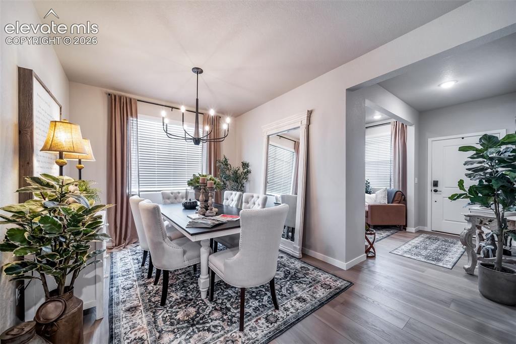 Image 13 of 45: Dining area featuring a contemporary chandelier, wood-finish flooring, whit