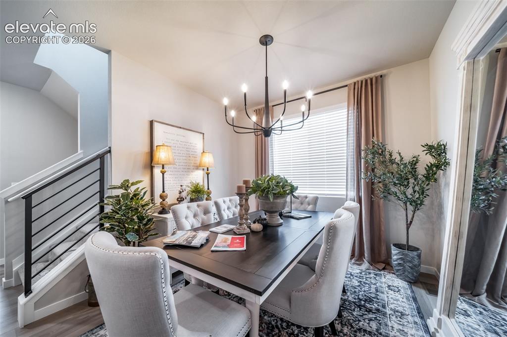 Image 14 of 45: Dining area featuring a dark wood-finish table with light upholstered chair